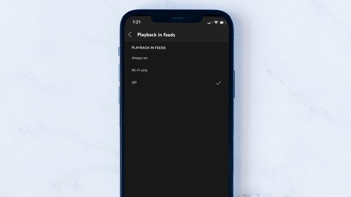 iPhone on white surface showing YouTube Thumbnail Autoplay settings option