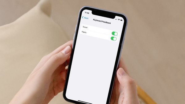 iPhone in hand showing Keyboard Haptics setting page