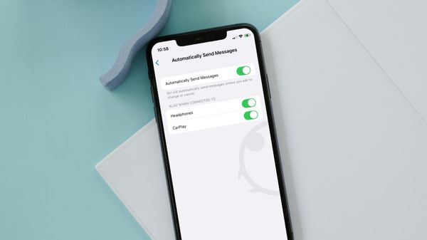 iPhone on white board on blue table showing Automatically Send Messages setting