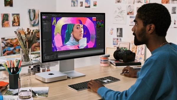 Man using M2 Mac mini on desk with mouse and keyboard