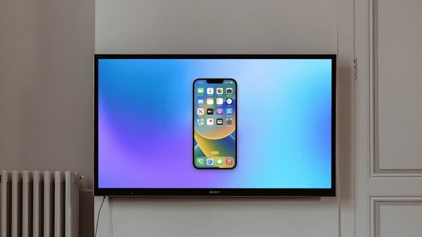 Wall mounted TV showing iPhone screen mirroring