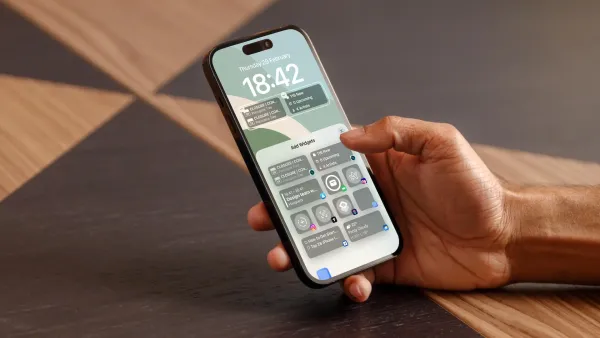Hand holding iPhone 15 Pro showing iPhone lock screen widgets