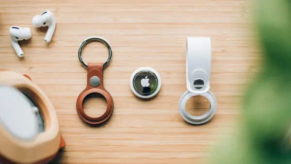 AirTag with holders, AirPods on wooden table