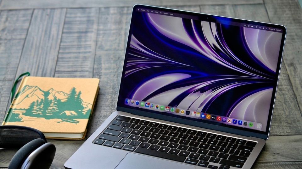 MacBook Air M32, Apple AirPods Max, and a notebook on wooden table