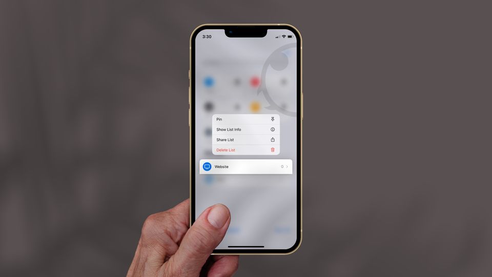 iPhone in hand with blurred background showing Pin list feature in Apple Reminders