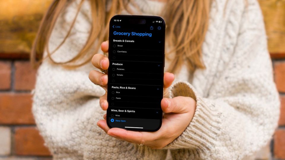 Girl holding iPhone showing Reminders Groceries list feature